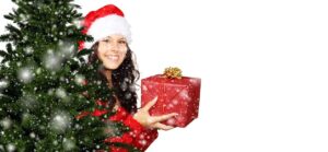 Pige bag juletræ giver gave